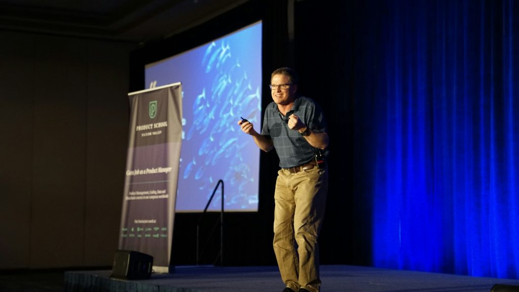 Professional speaker delivering a keynote on stage to a live audience at a speaking engagement