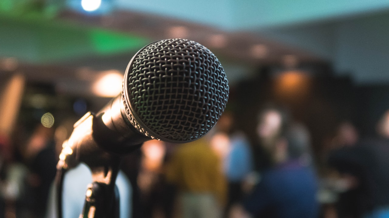 Microphone on stage before a speaking engagement with a blurred audience